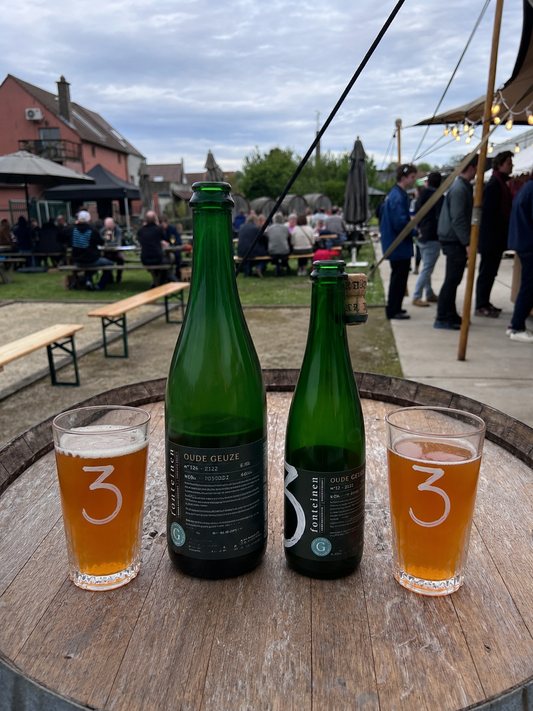 Drie Fonteinen Oude Kriek Blend 83 and Blend 118 side by side — two tulip glasses of deep garnet kriek, bottles behind